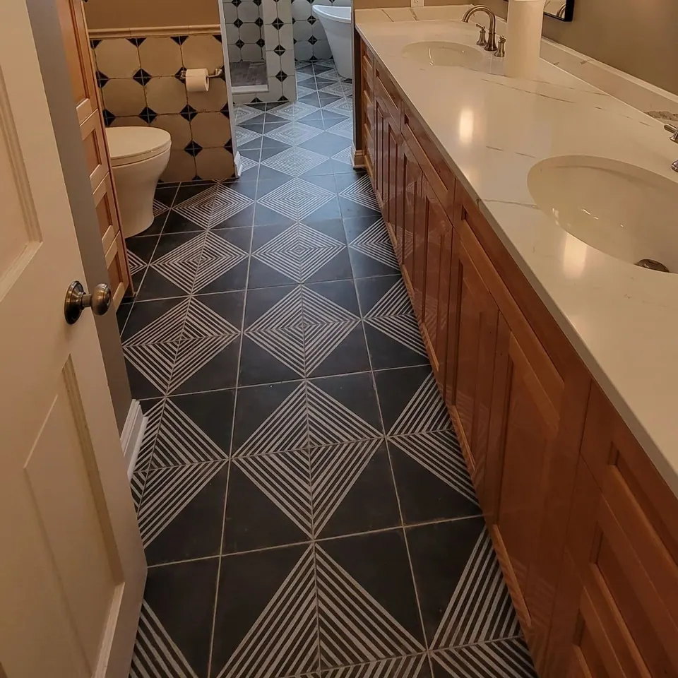 Patterned tile floor and wood vanity in the remodeled bathroom