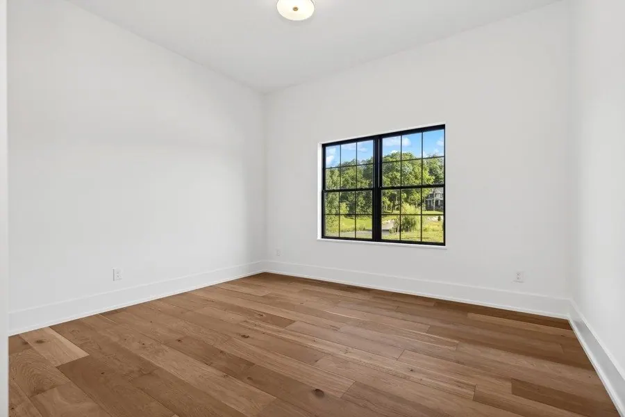 Empty room with fresh white walls and black window trim