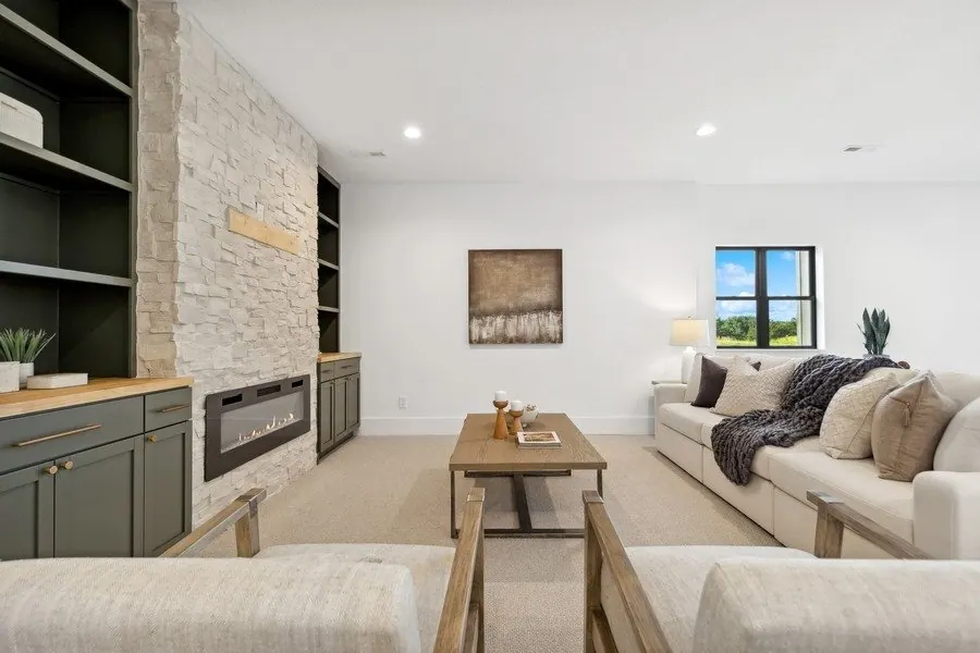 Enameled built-ins beside a stone fireplace