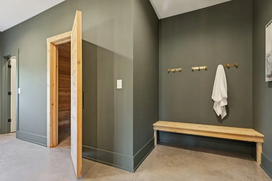 Hallway with greige walls, white trim and a bench