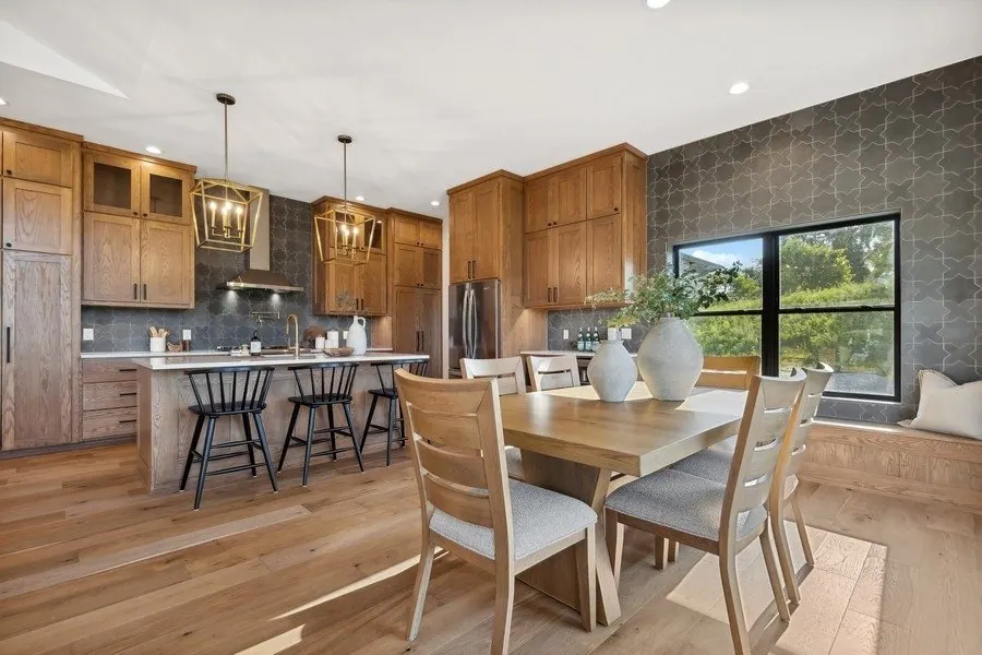 Kitchen island with pendant lights and stained wood cabinetry