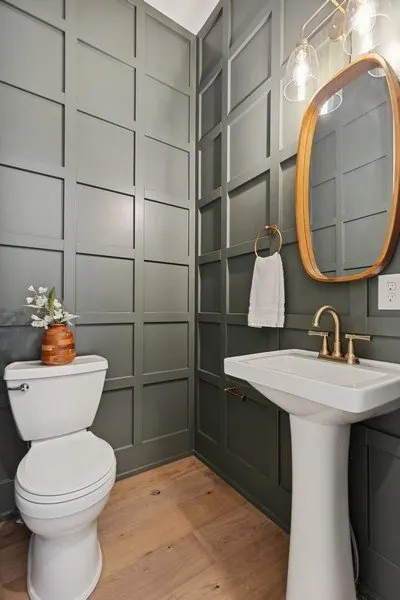Powder room with a painted green board and batten wall